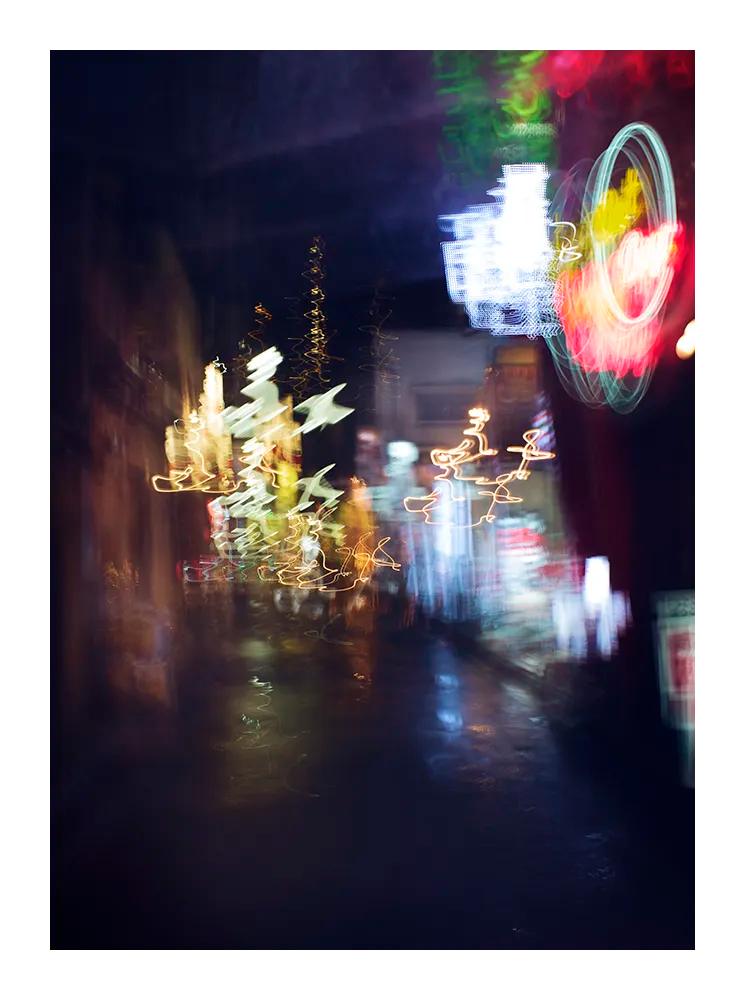 Fine art photograph of Tokyo at night with glowing neon lights and blurred reflections under the rain, printed in Sweden, exclusive at Monday Gallery.