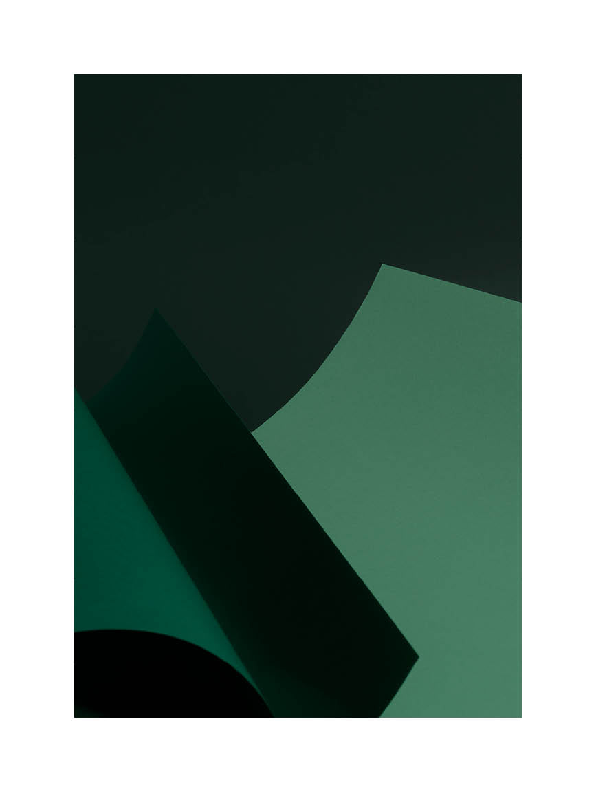 Abstrakt minimalistiskt fotografi med gröna former och mjuka linjer mot mörk bakgrund.