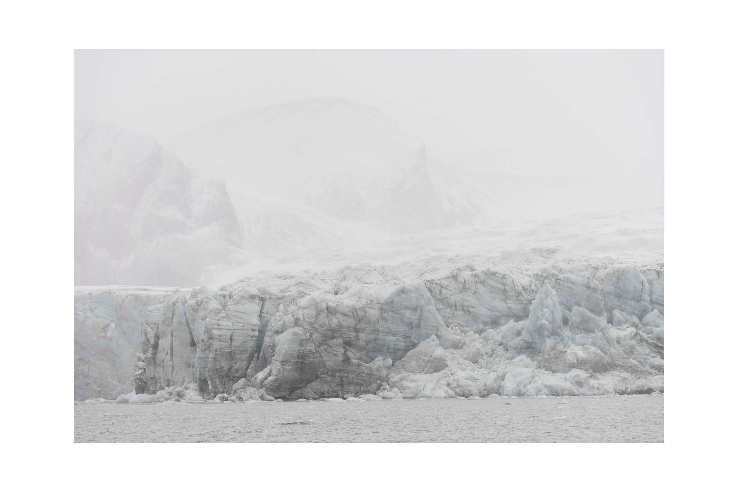 Minimalistiskt glaciärlandskap från Svalbard i dimma och mjuka grå toner. Stillness No.2, begränsad upplaga fine art print.