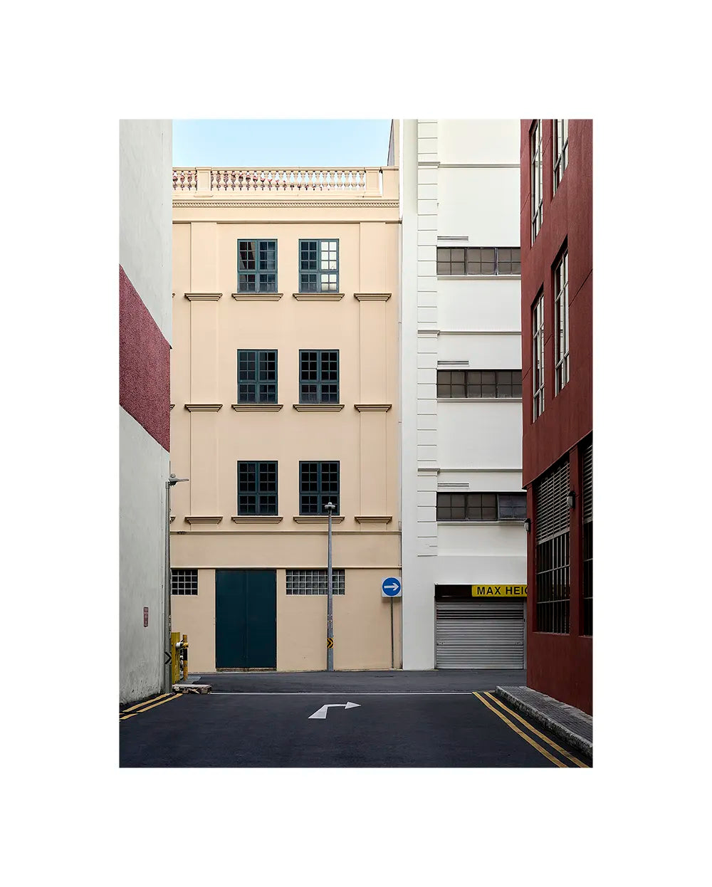 Minimalist architectural photograph of a narrow urban passage with pastel buildings and soft shadow lines