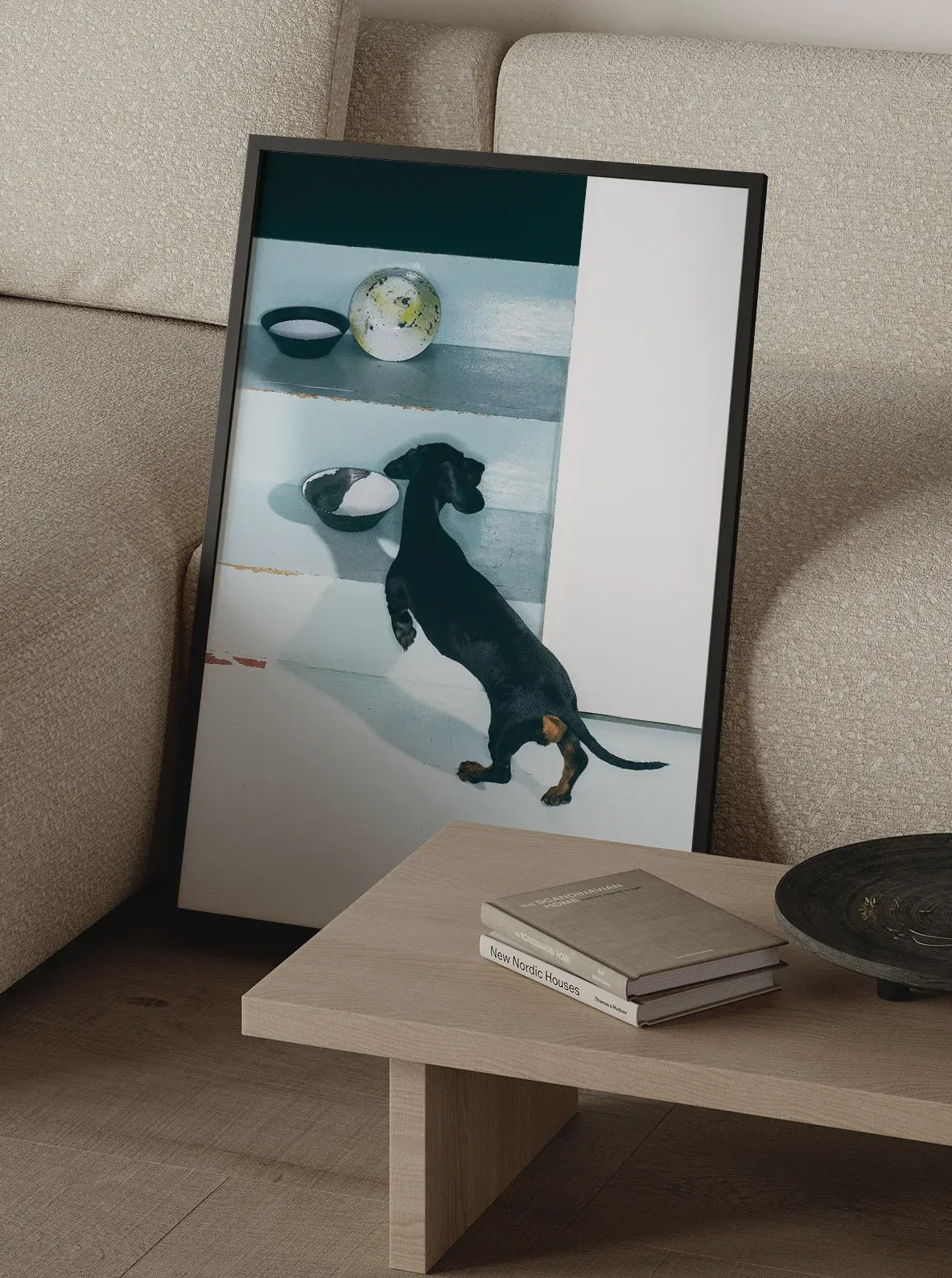 Framed Minimal Trouble fine art print featuring a black dachshund, styled in a modern Scandinavian living room with neutral tones and minimalist furniture