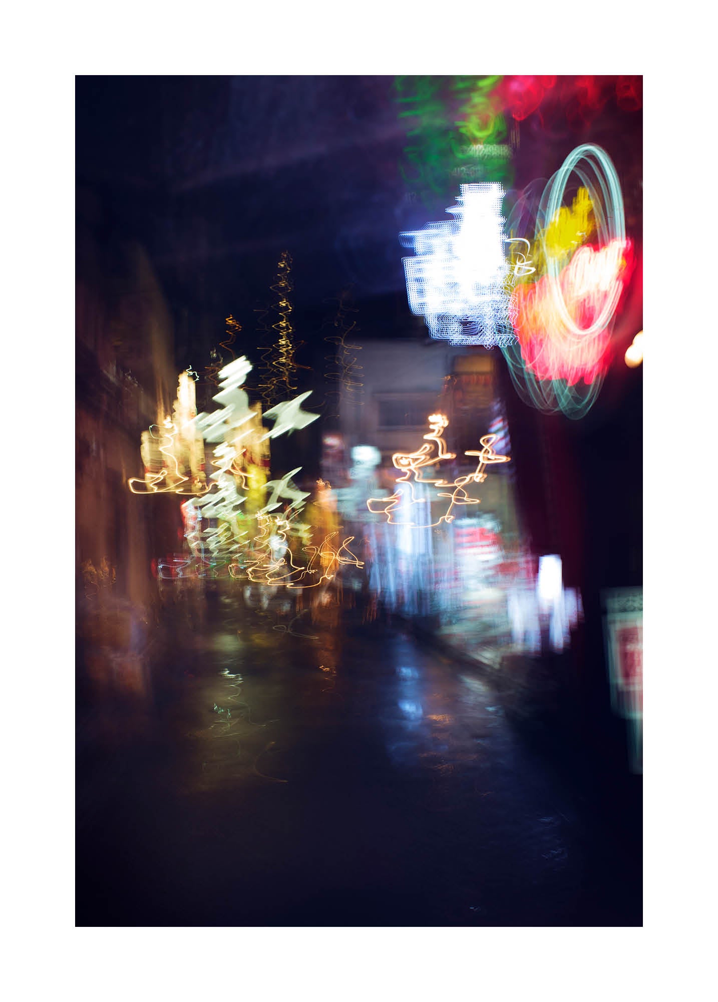 Fine art photograph of Tokyo at night with glowing neon lights and blurred reflections under the rain, printed in Sweden, exclusive at Monday Gallery.