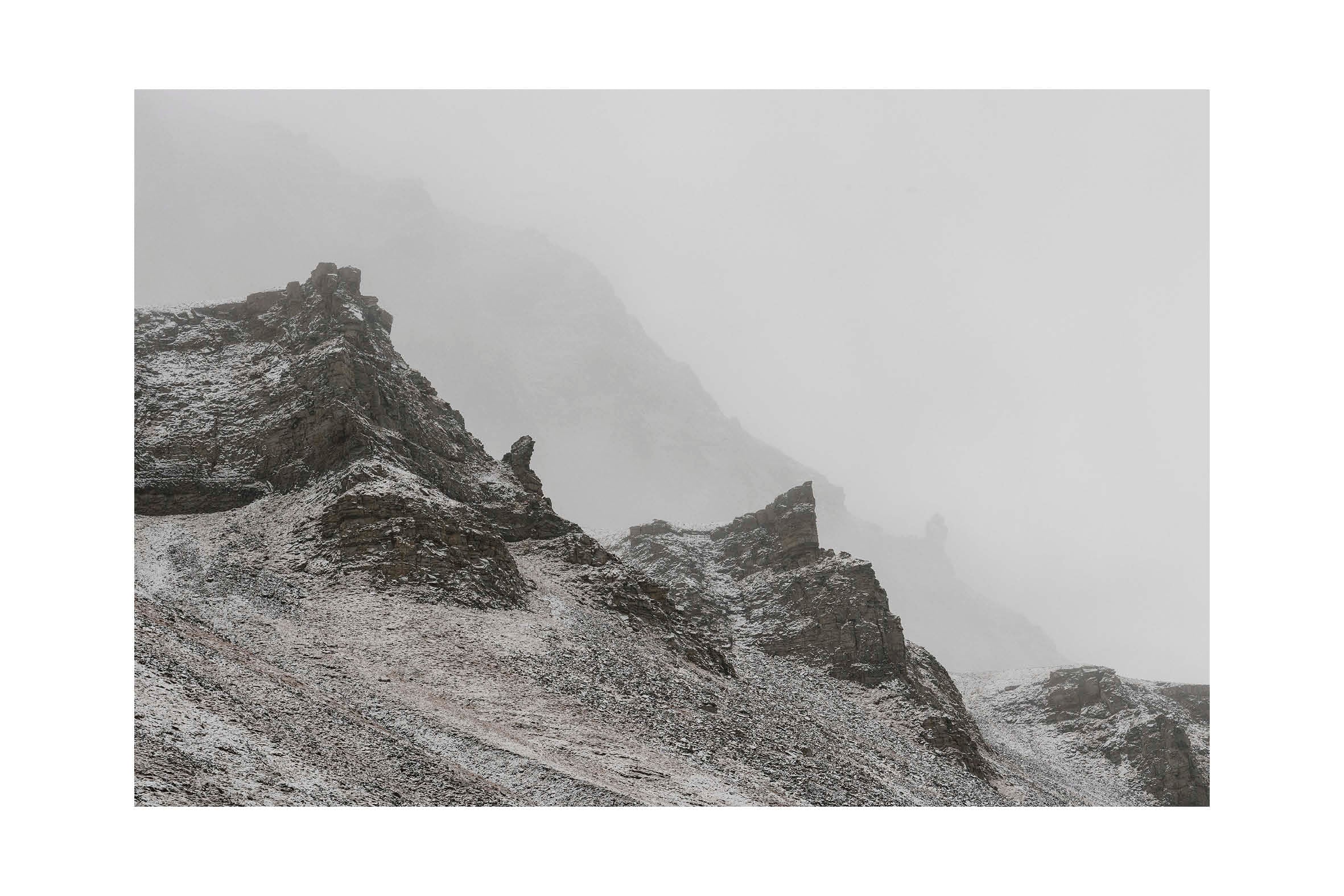 Minimalistiskt snötäckt bergslandskap från Svalbard i dimma och mjuka grå toner. Stillness No.1, begränsad upplaga fine art print.